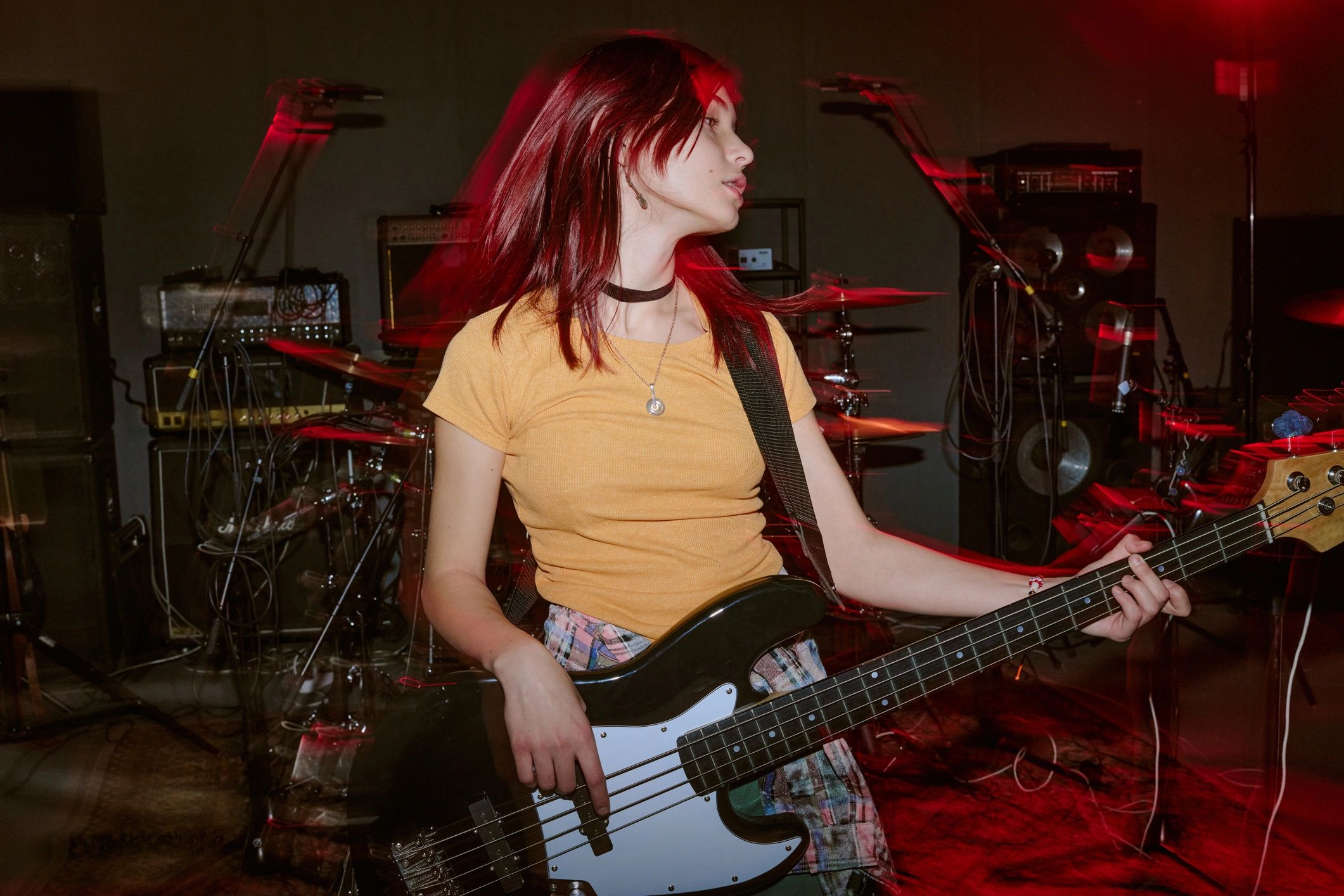 Guitarist playing electric guitar under red stage lighting