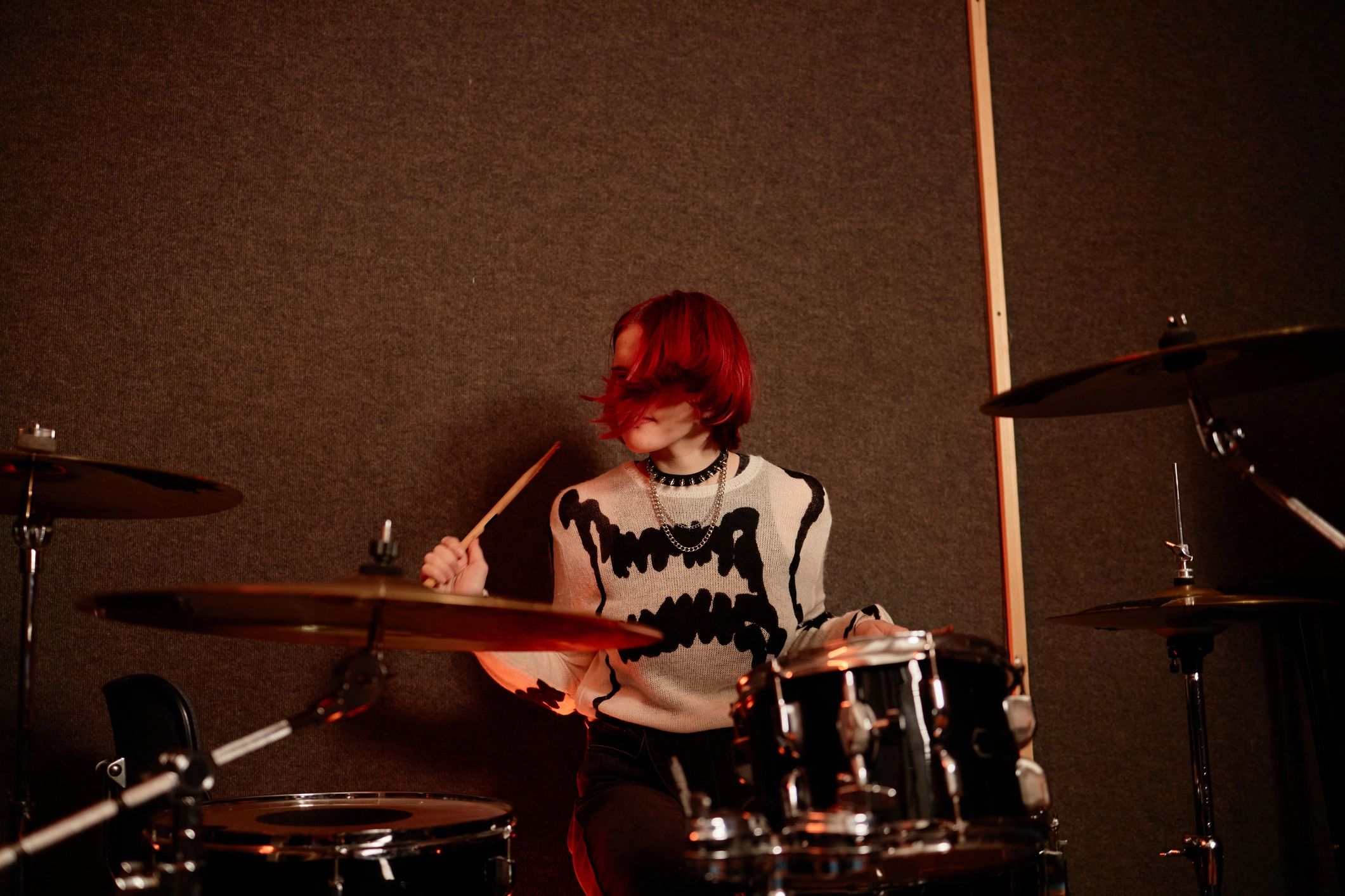 Drummer performing passionately on a drum kit